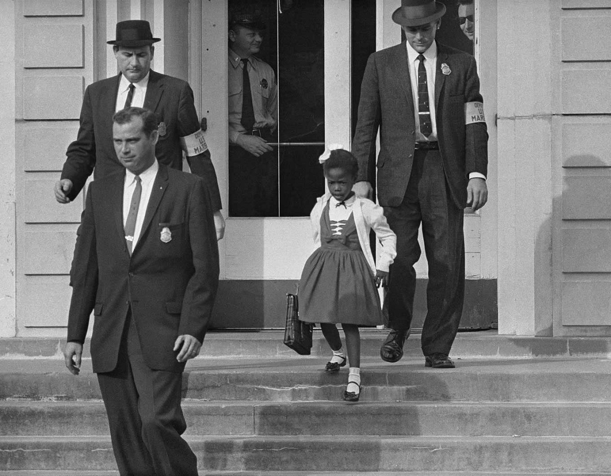 Η διάσημη φωτογραφία της Ruby Bridges, στην ηλικία των 6 ετών, στα σκαλιά του σχολείου. Προστατεύεται από ομοσπονδιακούς αστυνομικούς απέναντι σε ρατσιστές που δεν επιθυμούσαν τα έγχρωμα παιδιά στην εκπαίδευση. Νέα Ορλεάνη, Ηνωμένες Πολιτείες Αμερικής, πίσω στο 1960.